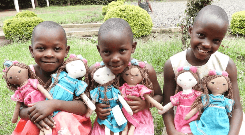 Three girls holding dolls