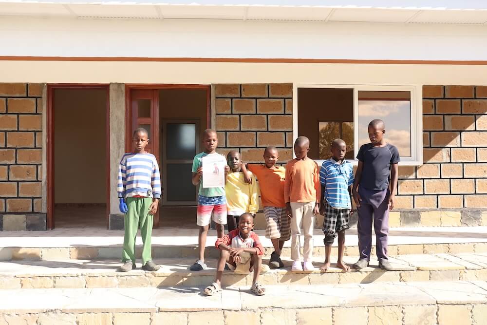 Boys with Archie poster outside Mfalme Mtoto House